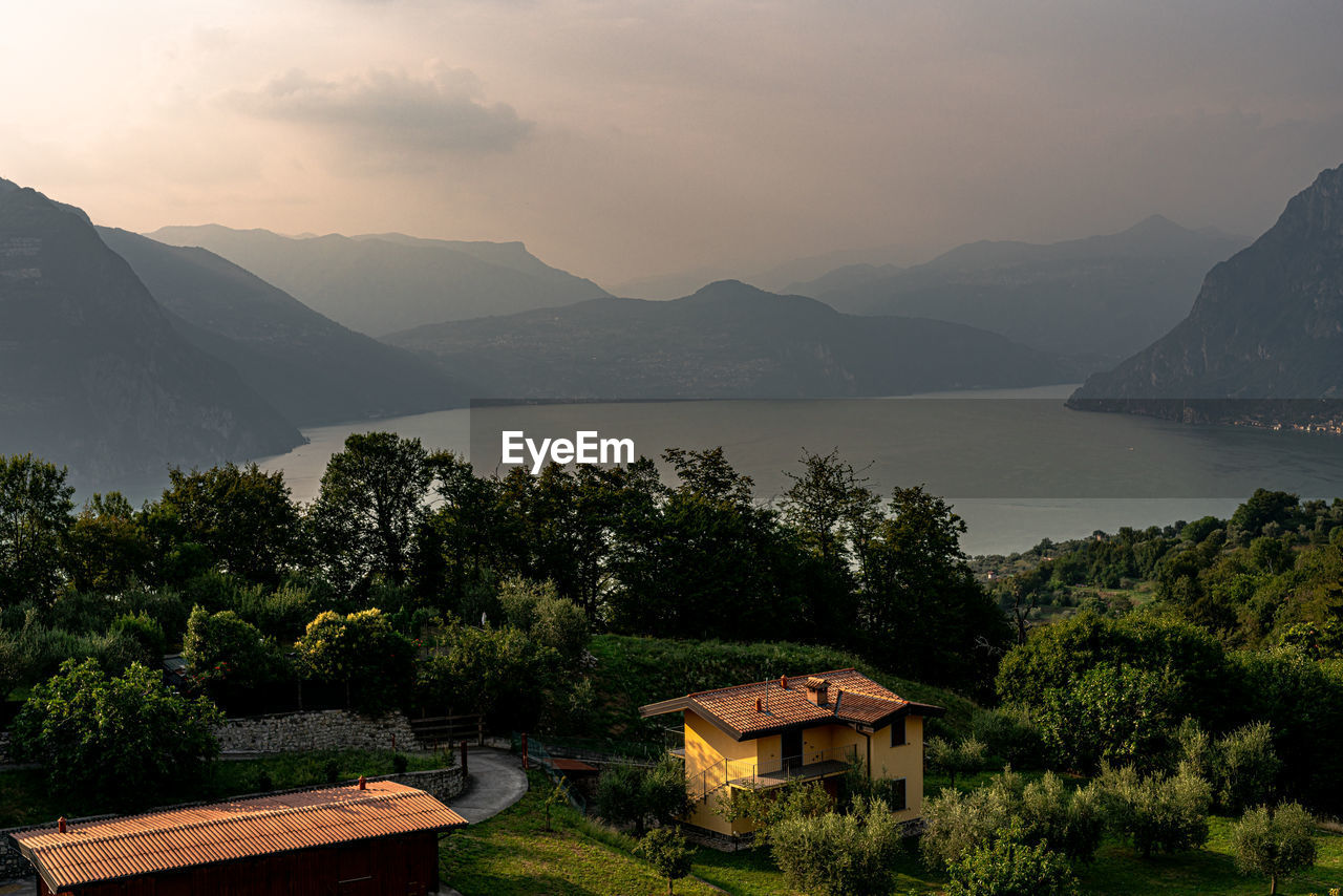 SCENIC VIEW OF LAKE AND BUILDINGS AGAINST MOUNTAINS