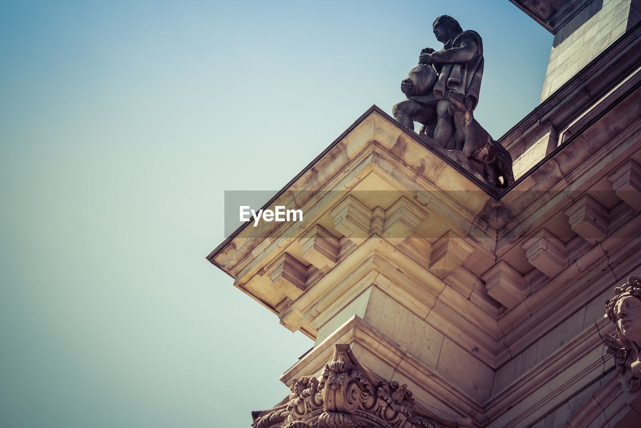 Low angle view of sculpture on reichstag building against clear sky