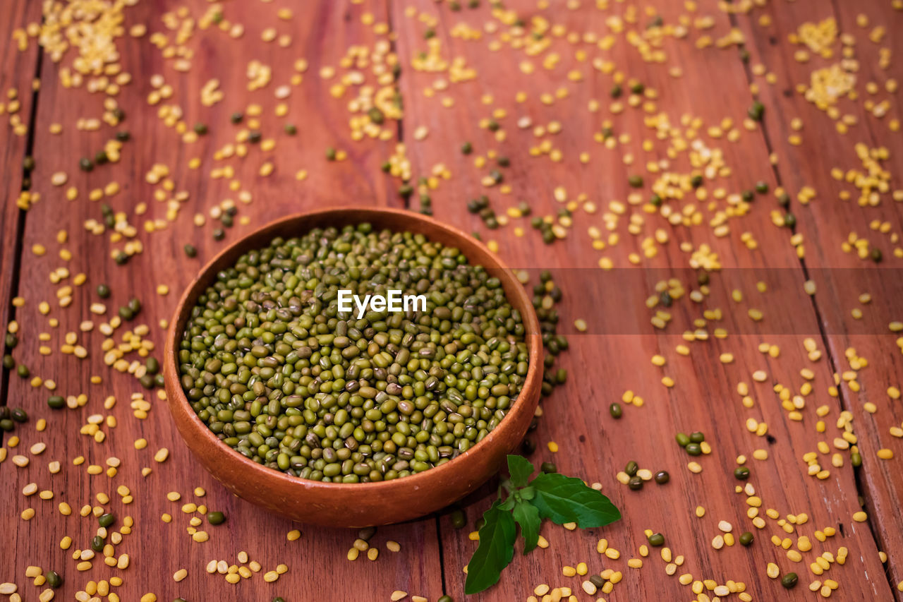 Organic mung beans in wooden bowl on wooden background