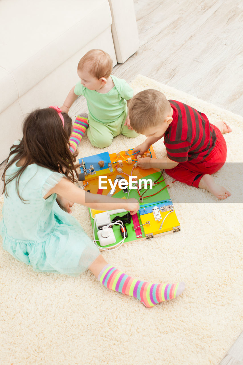 High angle view of children playing with toy on floor