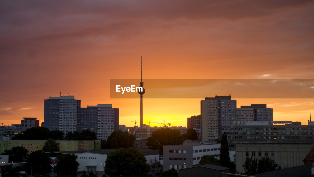 Fernsehturm tower with cityscape against sky during sunset