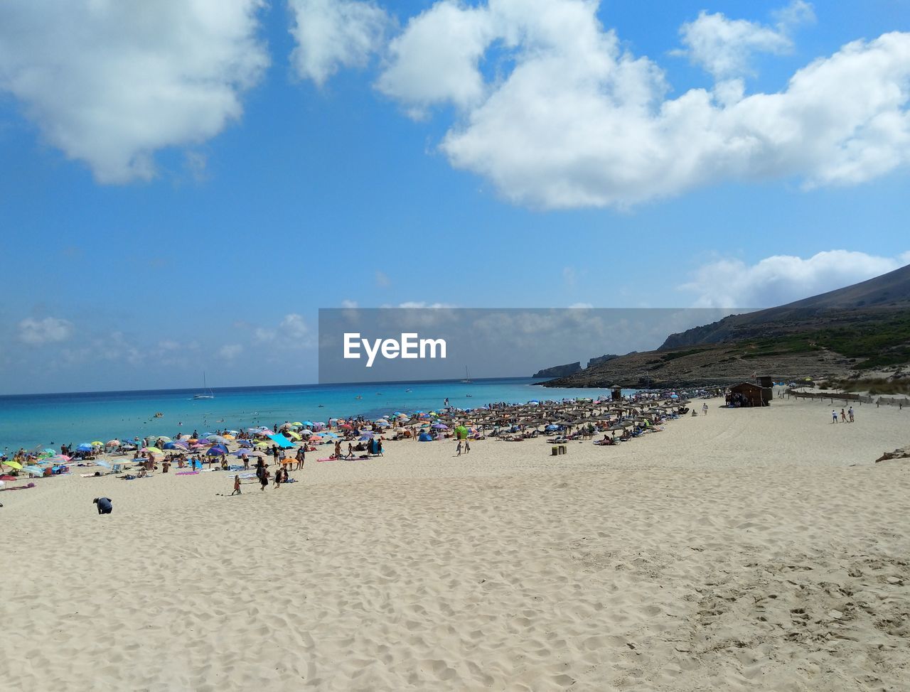 Group of people on beach against sky