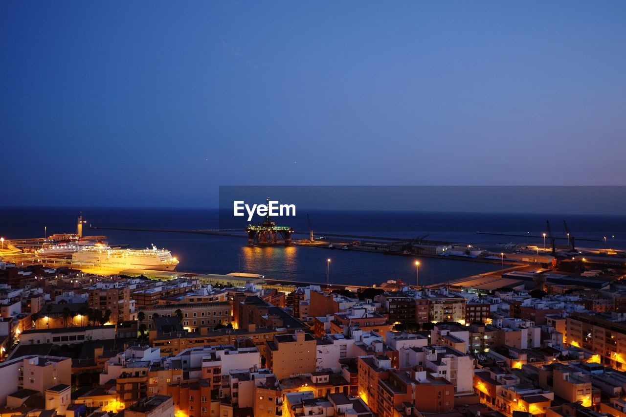 HIGH ANGLE VIEW OF ILLUMINATED CITYSCAPE AT NIGHT