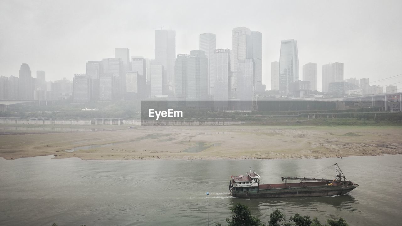 SCENIC VIEW OF RIVER AND CITYSCAPE AGAINST SKY