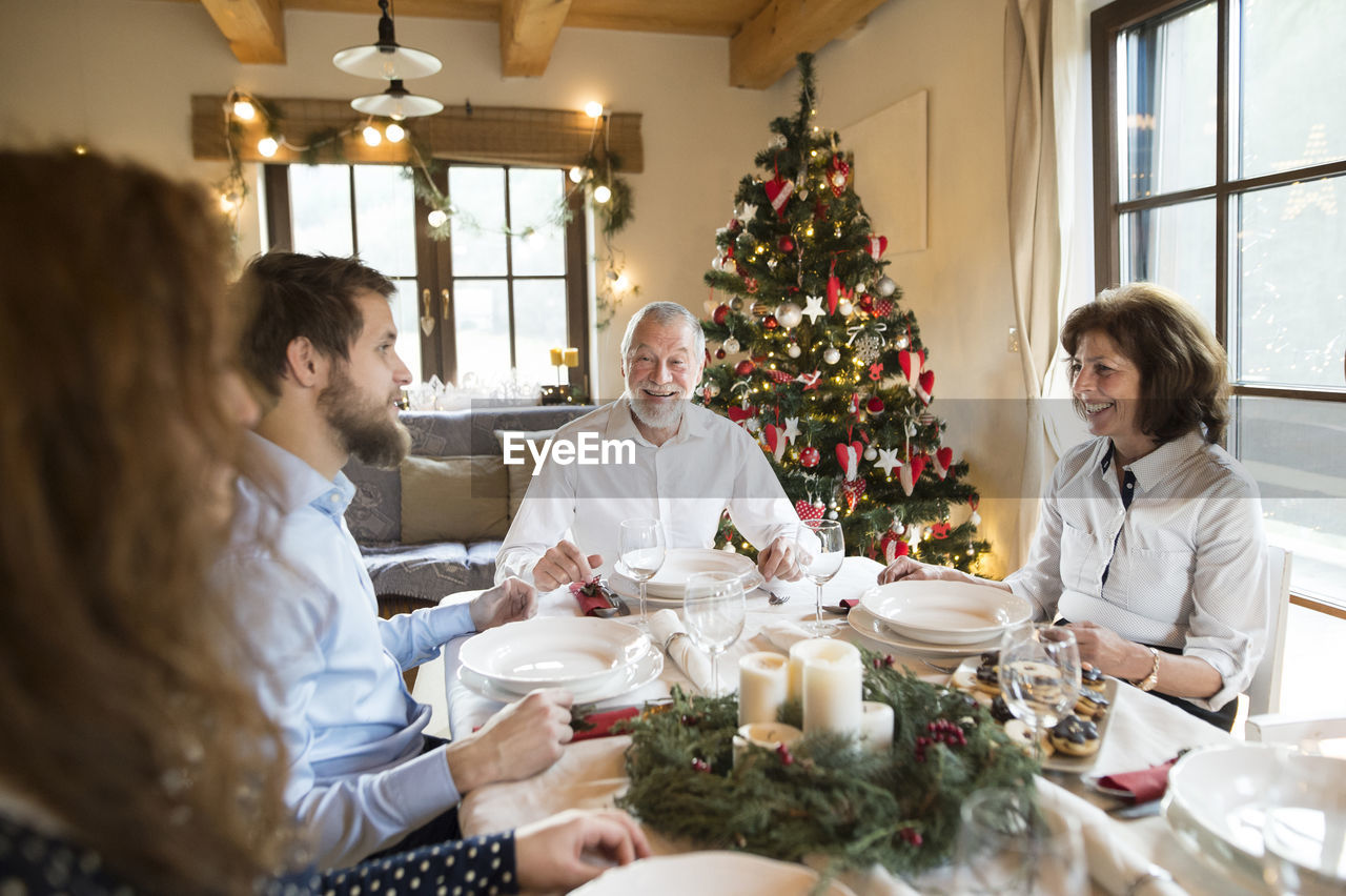 Smiling senior man with family at christmas dinner table