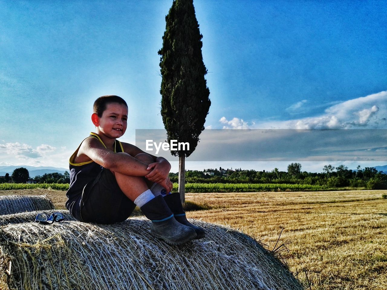 YOUNG MAN SITTING IN FIELD