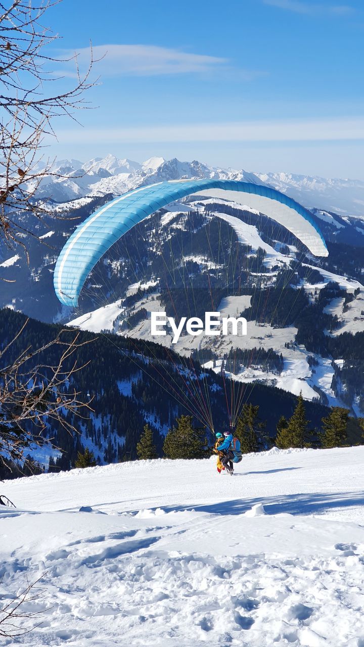 MAN SKIING ON SNOWCAPPED MOUNTAIN AGAINST SKY