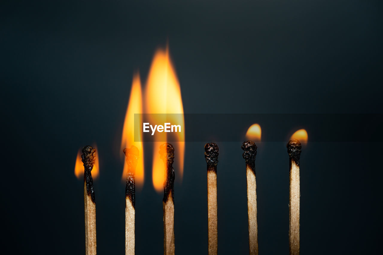 CLOSE-UP OF BURNING CANDLE