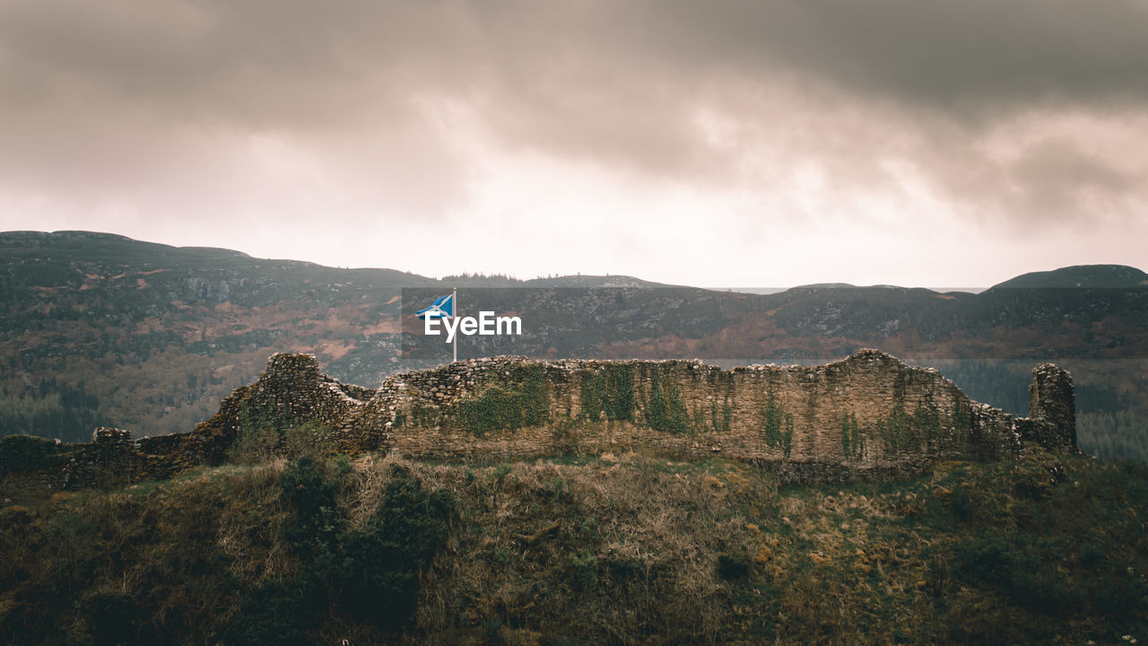 Scenic view of mountains against cloudy sky