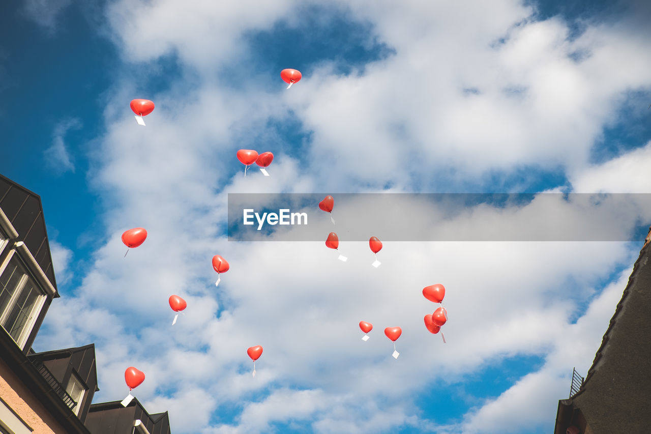 Low angle view of balloons flying against sky