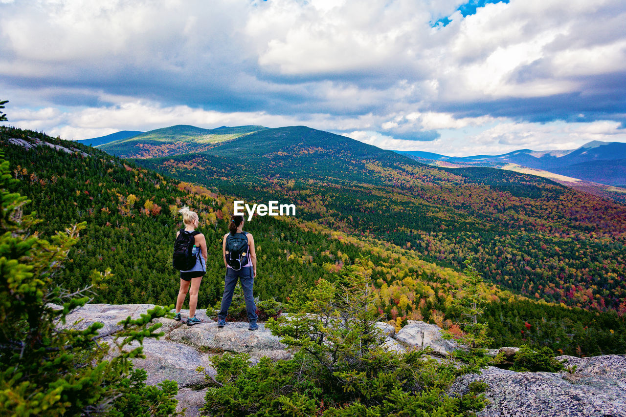 MAN STANDING ON MOUNTAIN AGAINST SKY