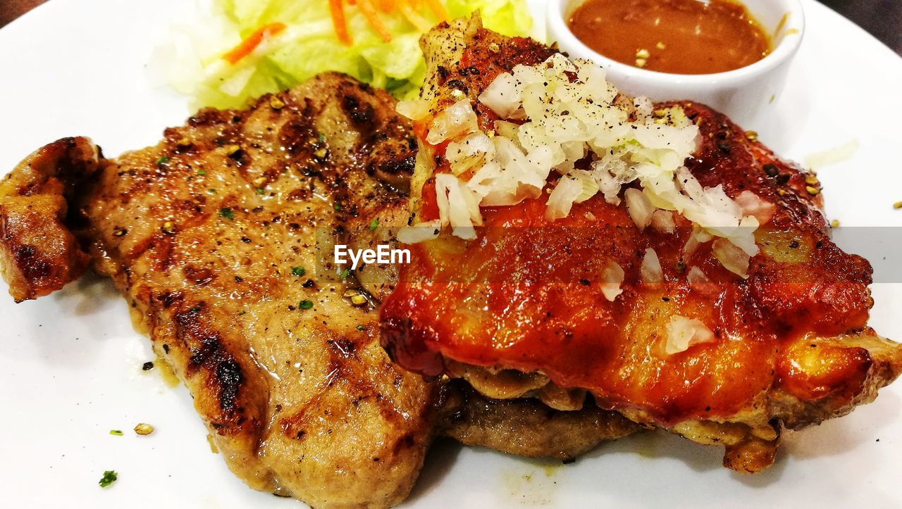 CLOSE-UP OF MEAT AND SALAD IN PLATE