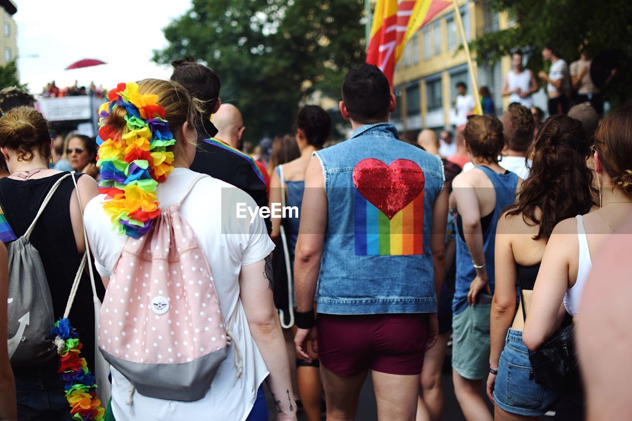 REAR VIEW OF PEOPLE WALKING IN CITY