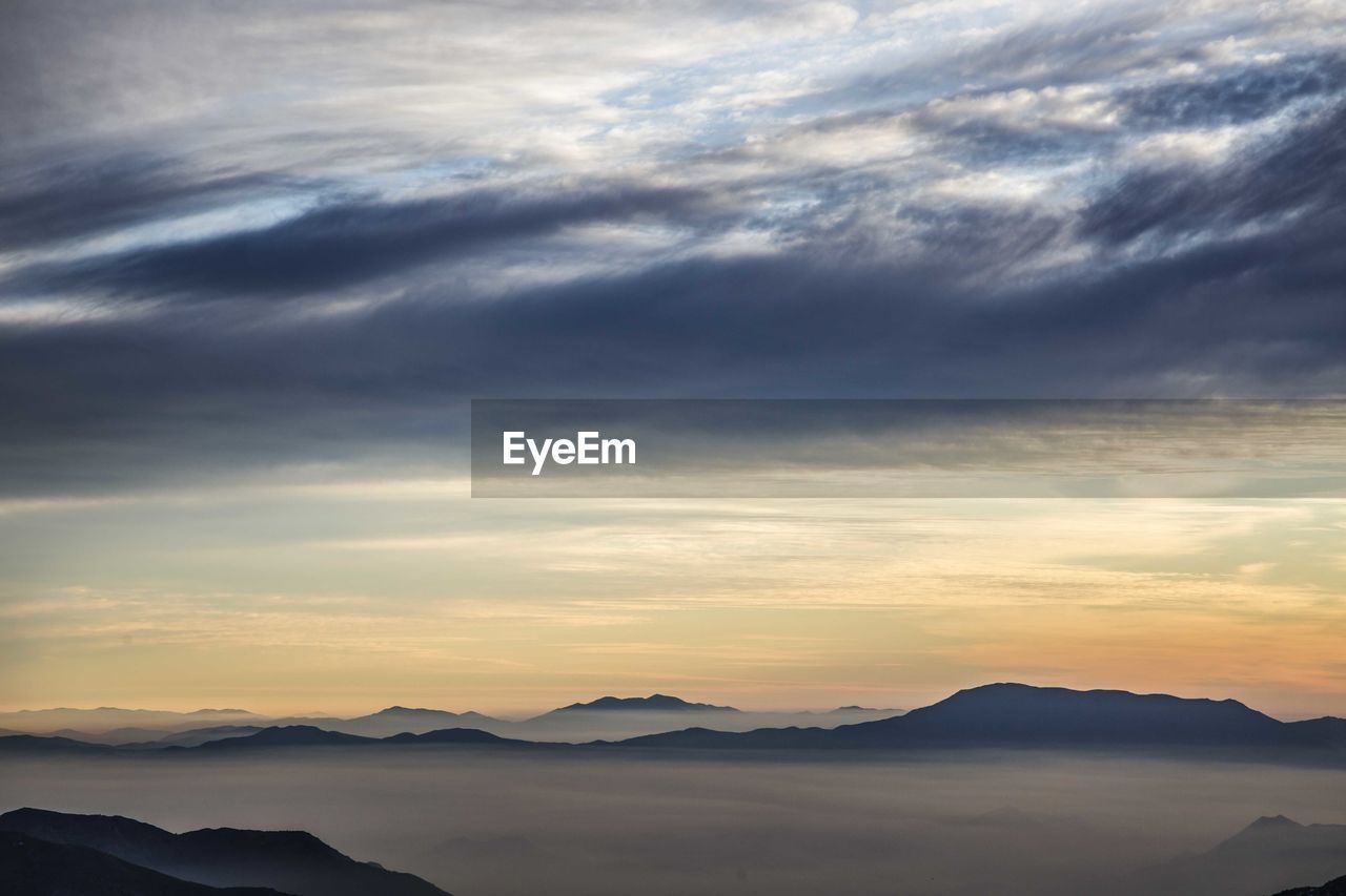 Scenic view of silhouette mountains against sky at sunset