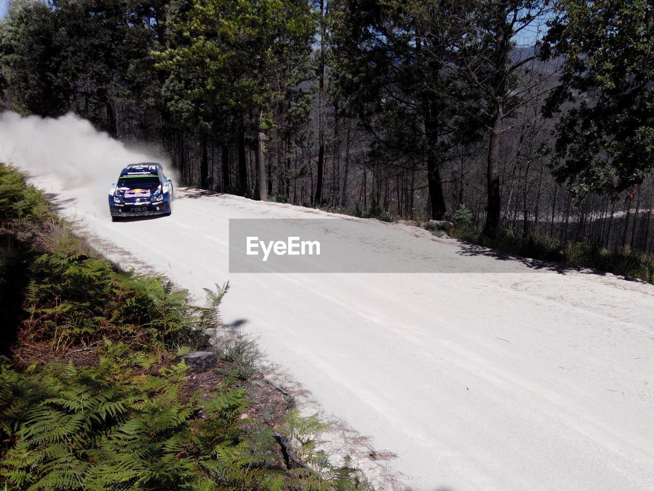 Racecar on dirt road with dust