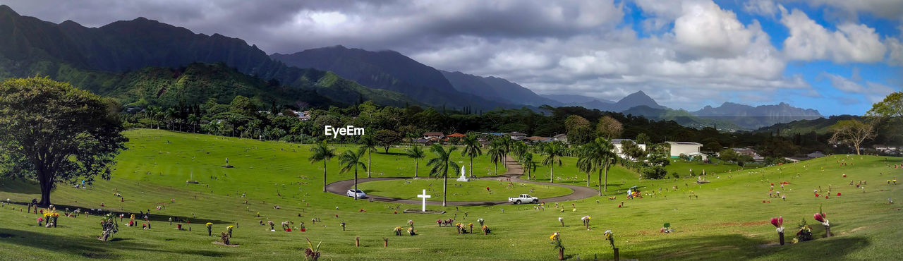 PANORAMIC VIEW OF FIELD AND MOUNTAINS AGAINST SKY