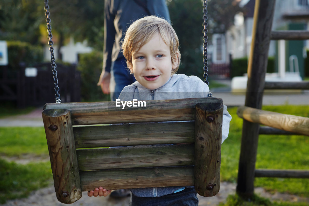 Portrait of smiling boy on slide at playground