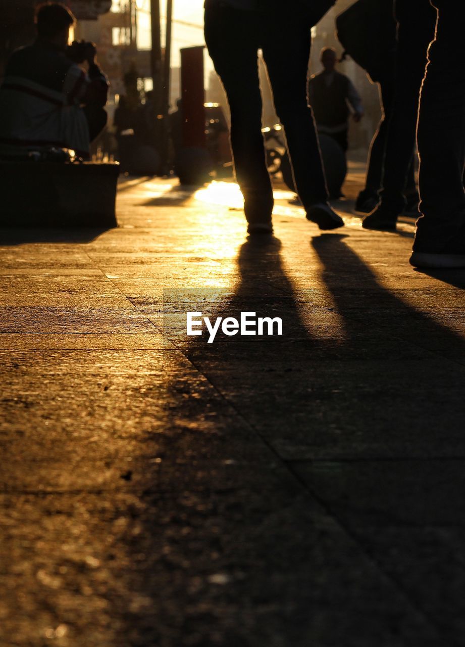 Silhouette of low section of people standing outdoors