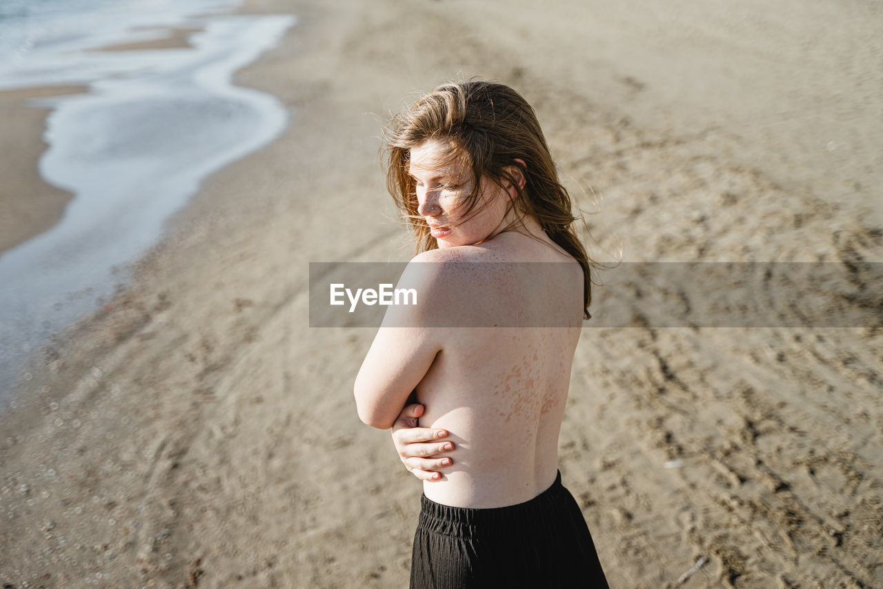 Seductive woman standing at beach