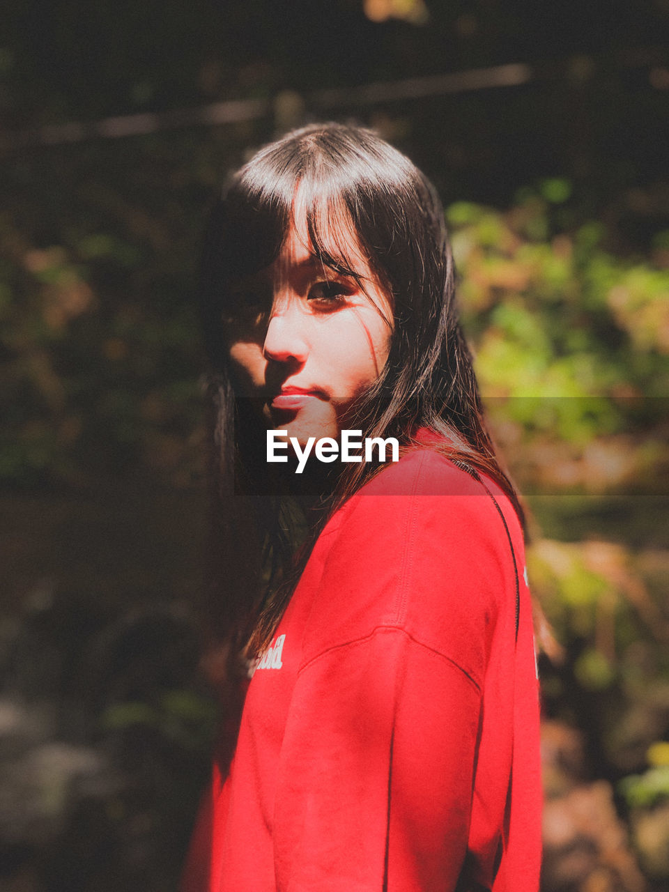 PORTRAIT OF A BEAUTIFUL YOUNG WOMAN IN RED OUTDOORS