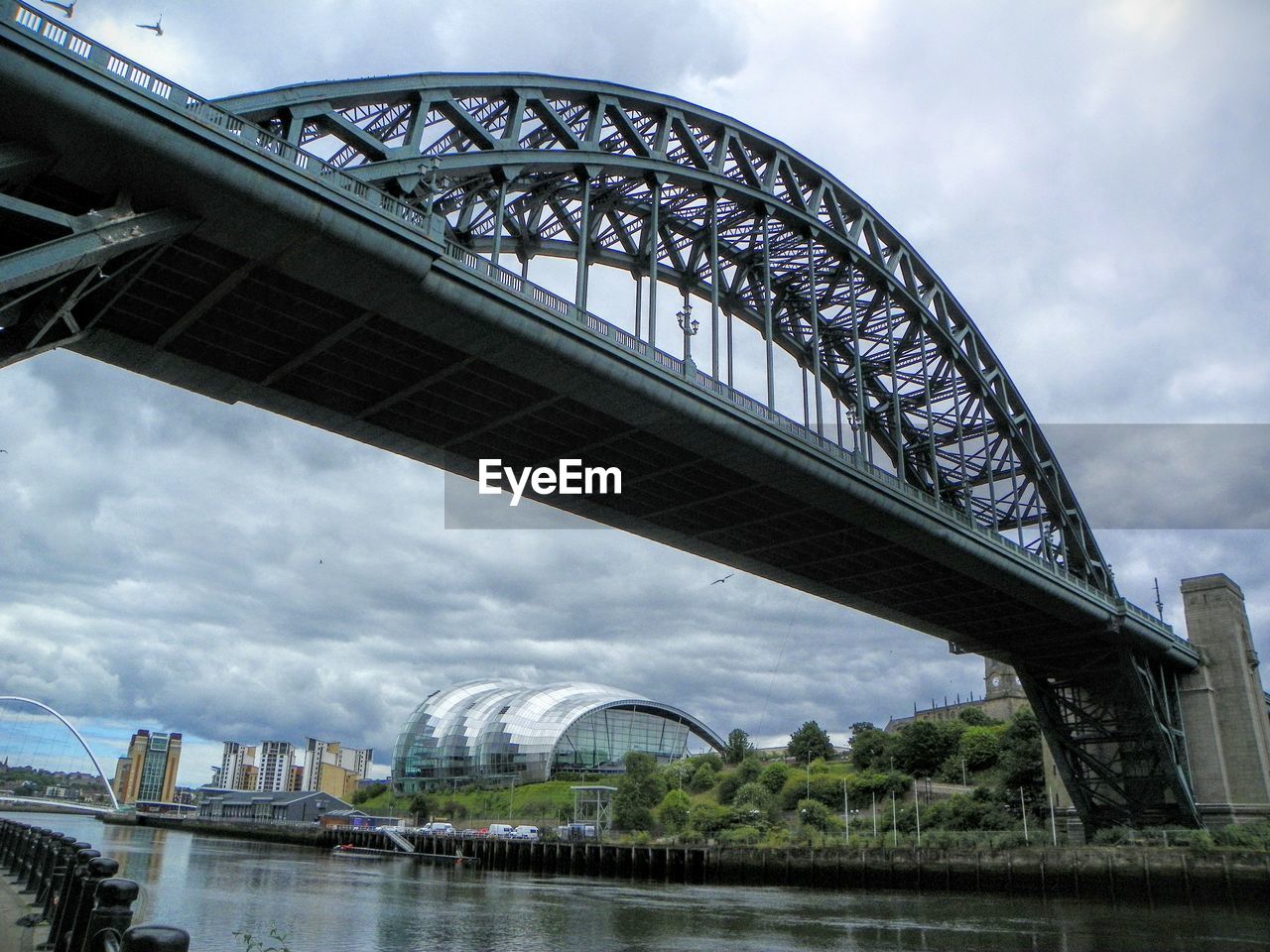 BRIDGE OVER RIVER WITH CITY IN BACKGROUND