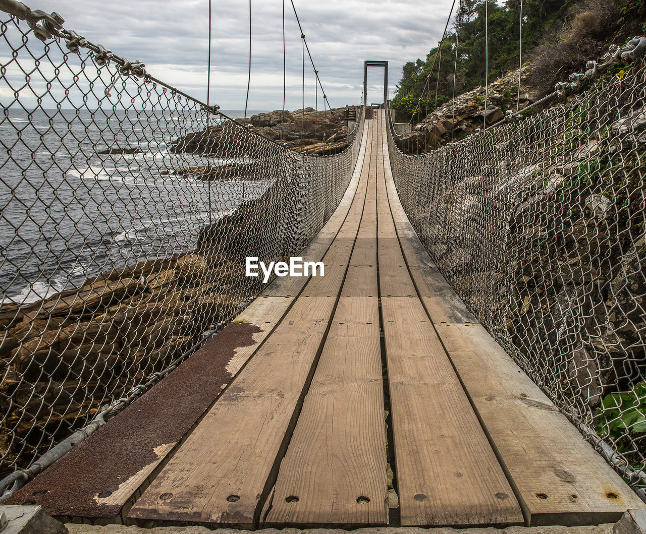 View of footbridge through chainlink fence