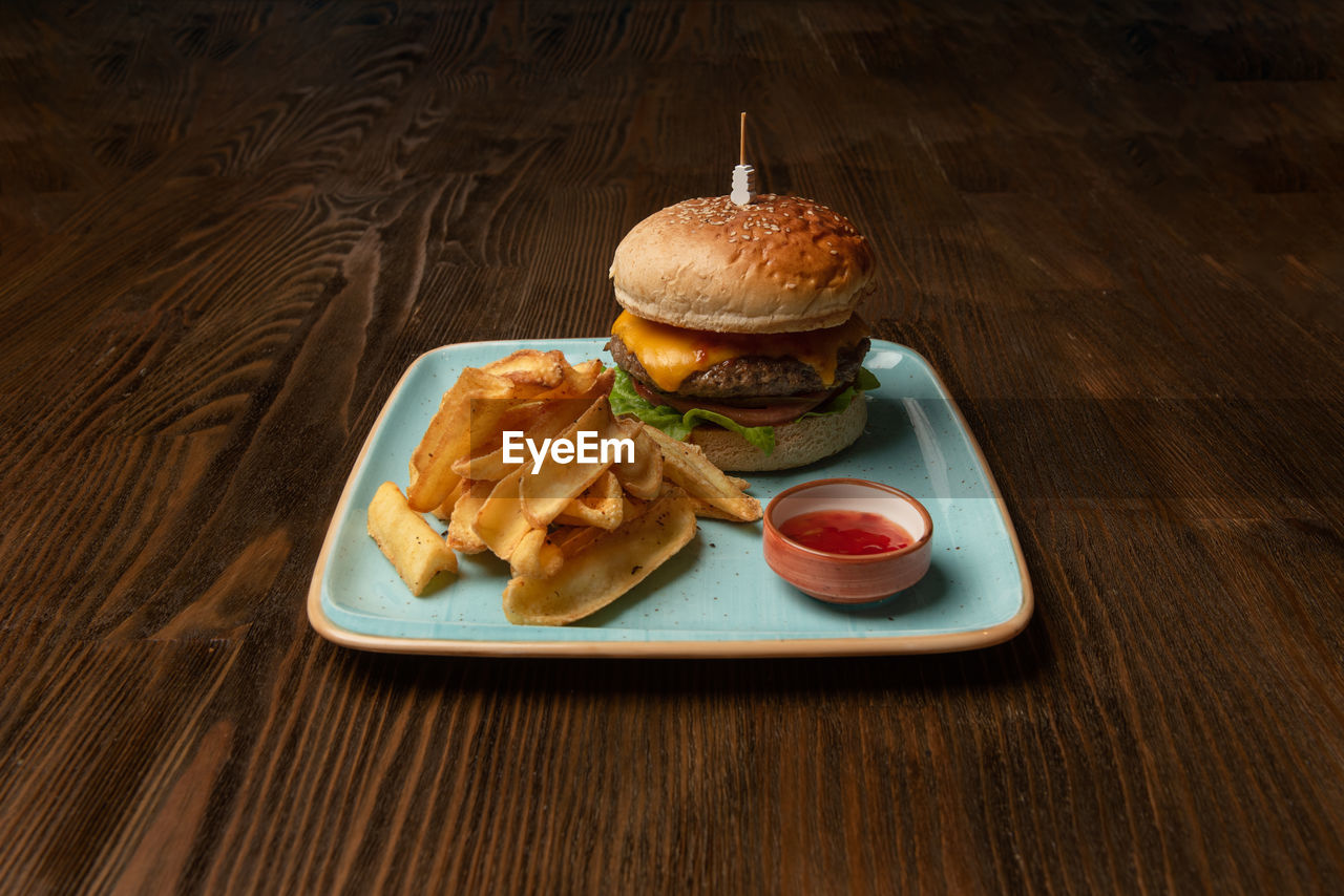 High angle view of burger and french fries in plate on table