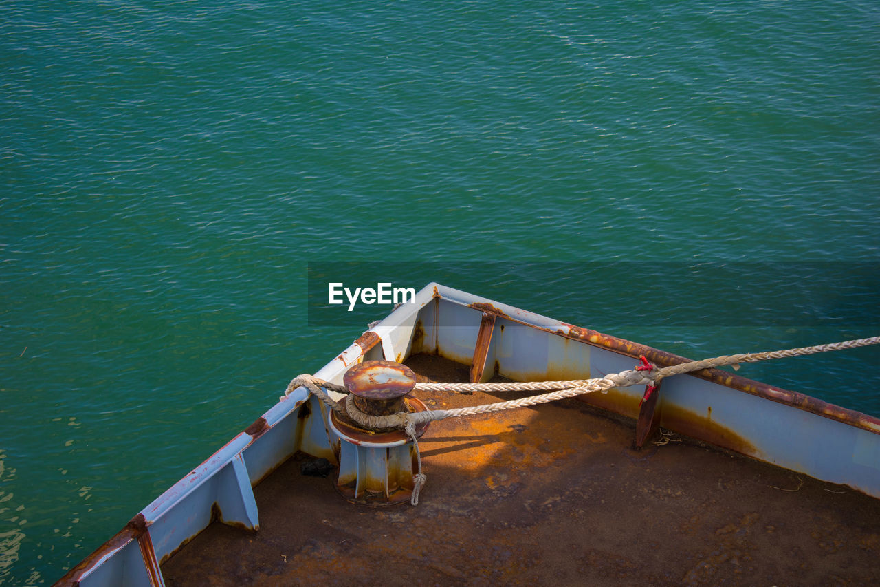 High angle view of rope tied on rusty bollard