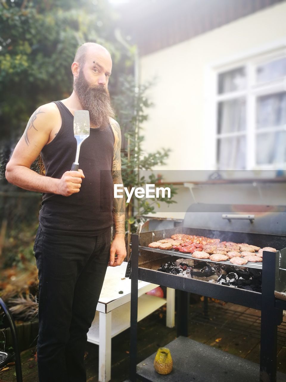 MAN STANDING ON BARBECUE