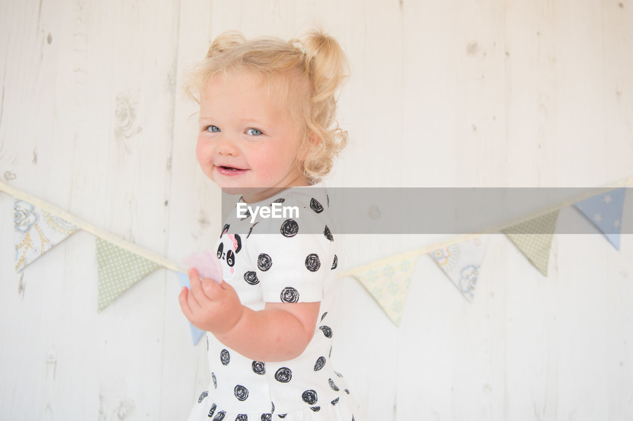 Portrait of cute baby girl standing at home