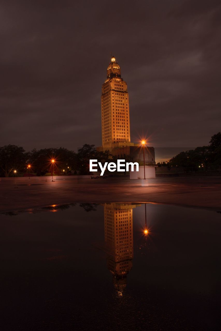 Skyscraper reflecting in puddle at night