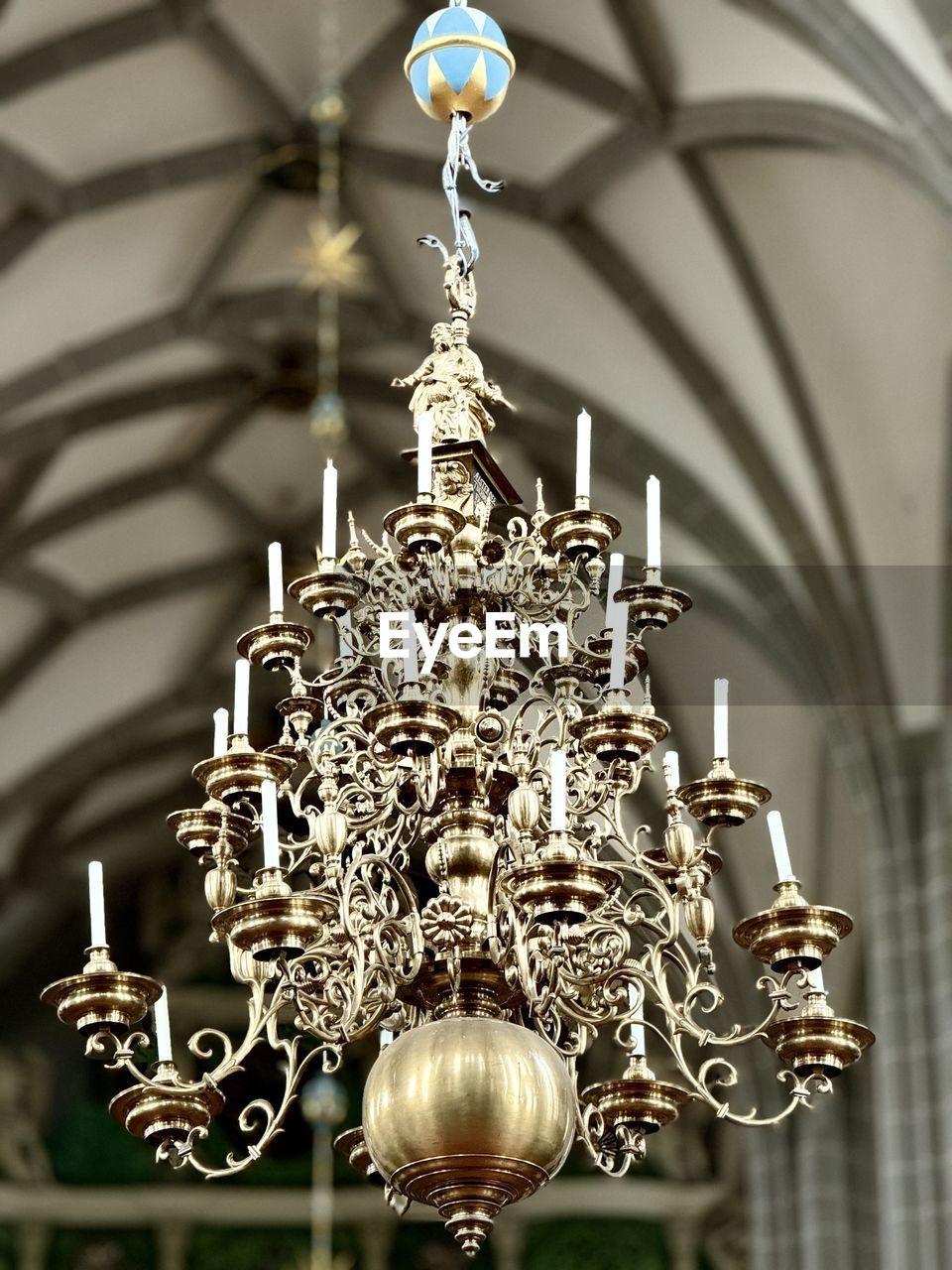 chandelier, light fixture, hanging, lighting equipment, lighting, ceiling, architecture, decoration, no people, low angle view, built structure, indoors, ornate, pendant light, wealth, focus on foreground, luxury, illuminated, building, religion, metal, spirituality, close-up, pattern, belief