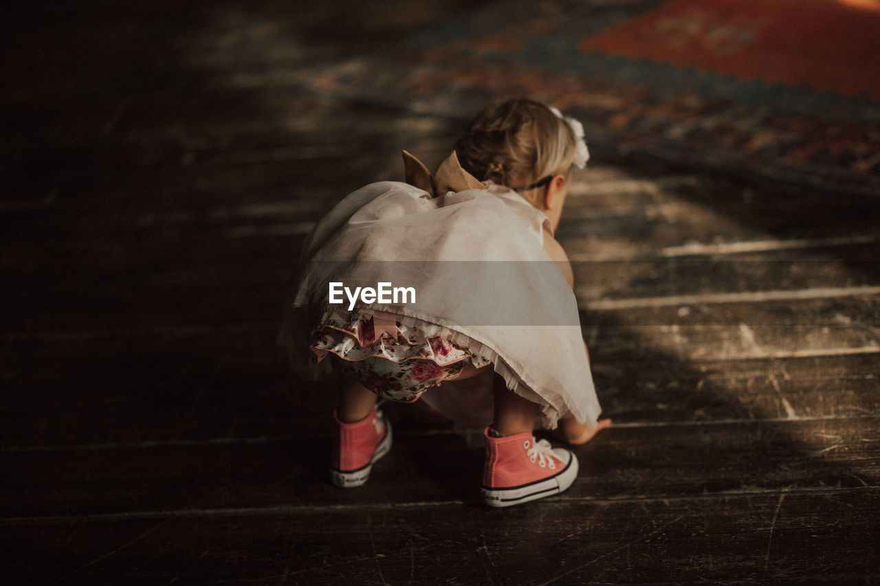 Rear view of baby girl bending on floor