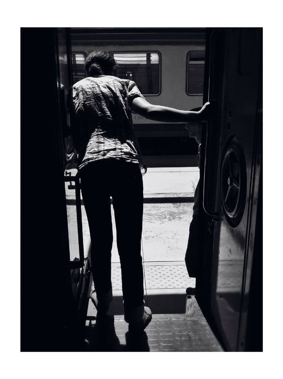FULL LENGTH OF WOMAN STANDING ON RAILROAD PLATFORM