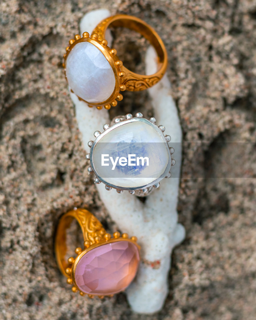 Gem stone rings on a coral on the beach, jewelry product photos