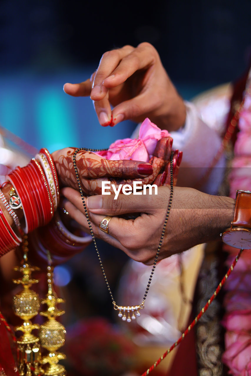 Midsection of couple performing traditional ritual