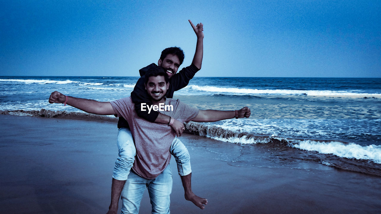 Portrait of cheerful friends enjoying on beach