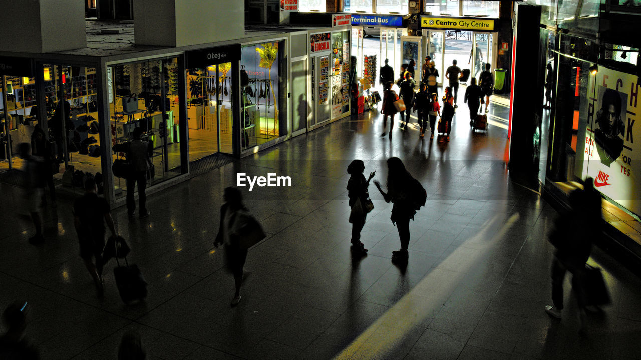 HIGH ANGLE VIEW OF PEOPLE STANDING IN ILLUMINATED UNDERGROUND