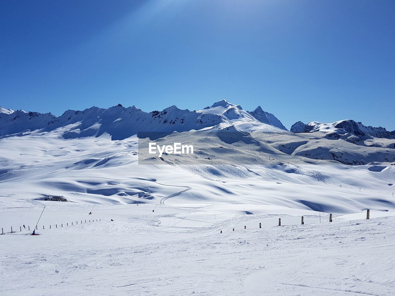 Scenic view of snowcapped mountains against clear blue sky