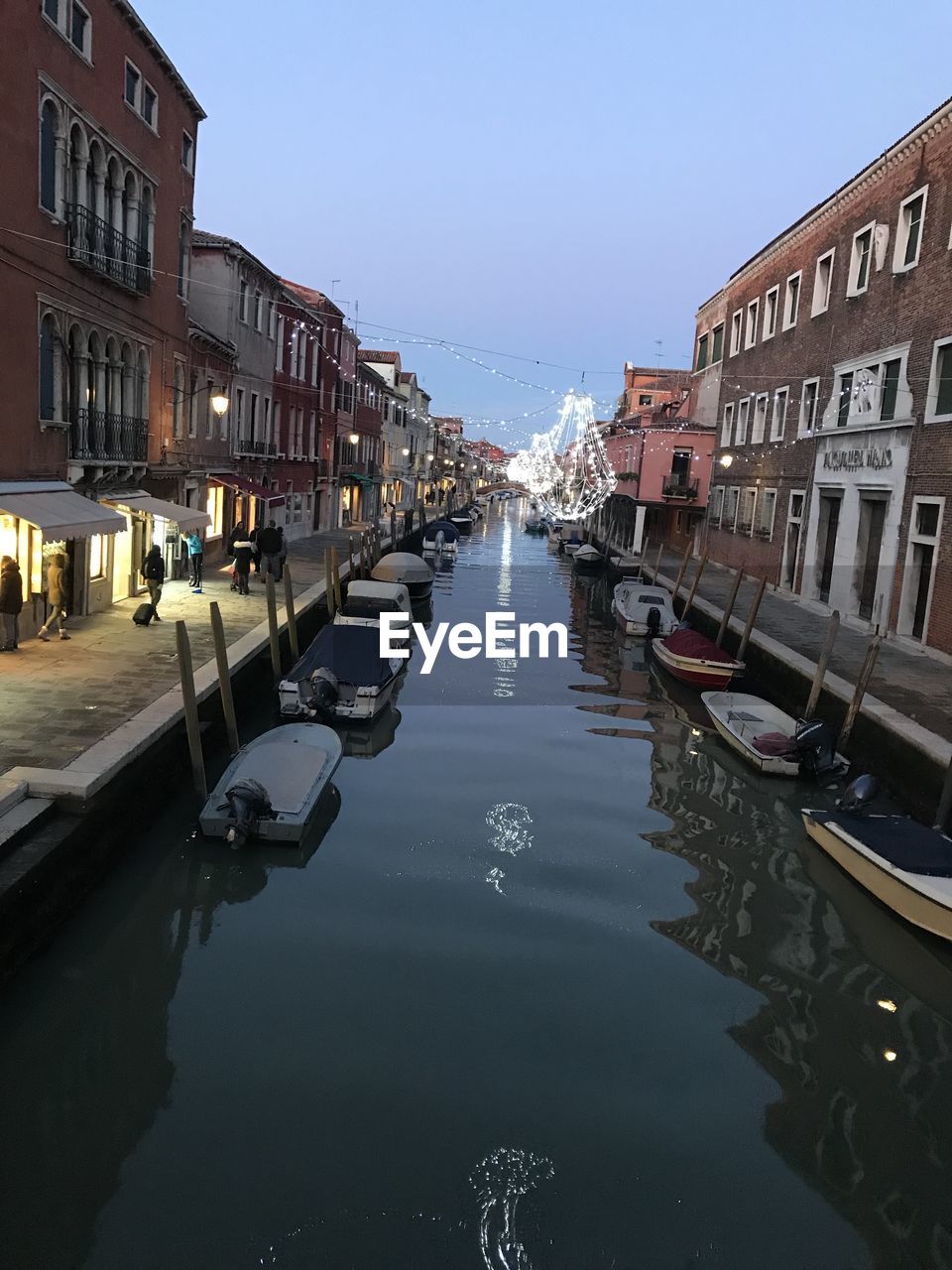 BOATS IN CANAL AMIDST BUILDINGS IN CITY