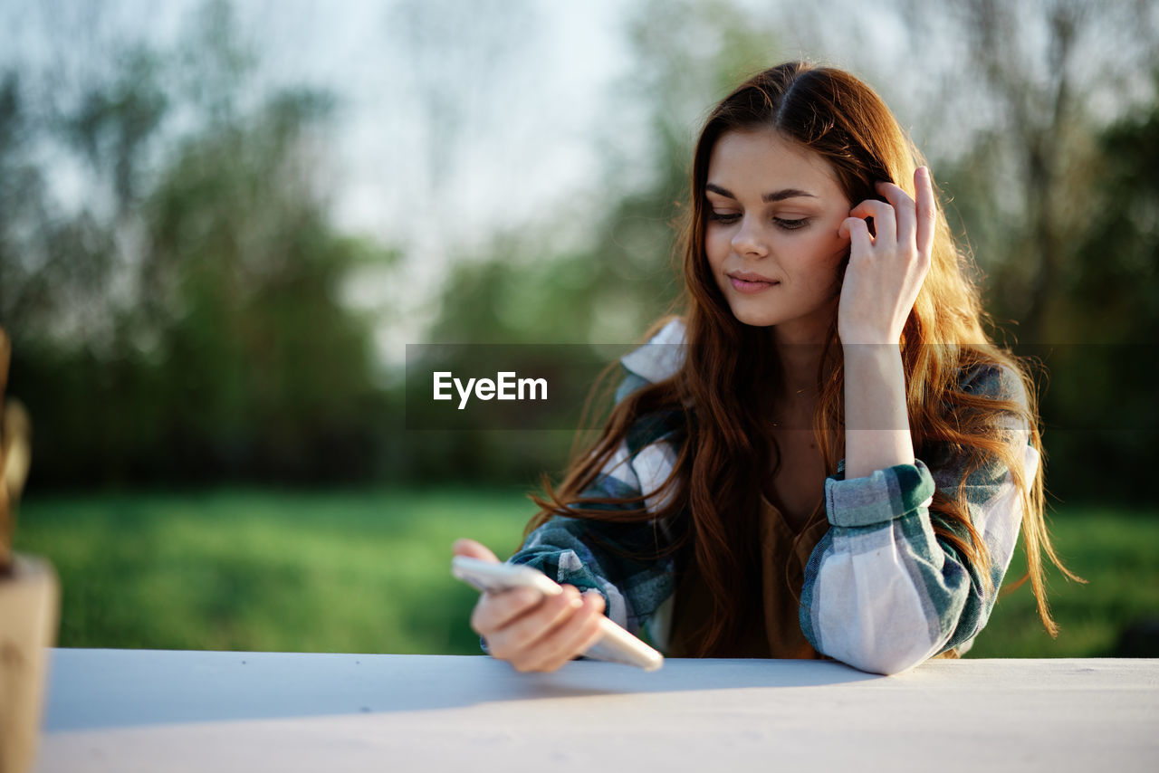 smiling young woman using mobile phone