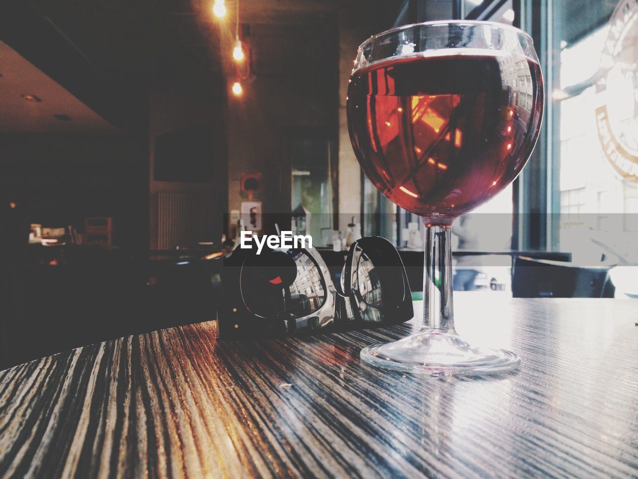 Close-up of wine glass and sunglasses on table