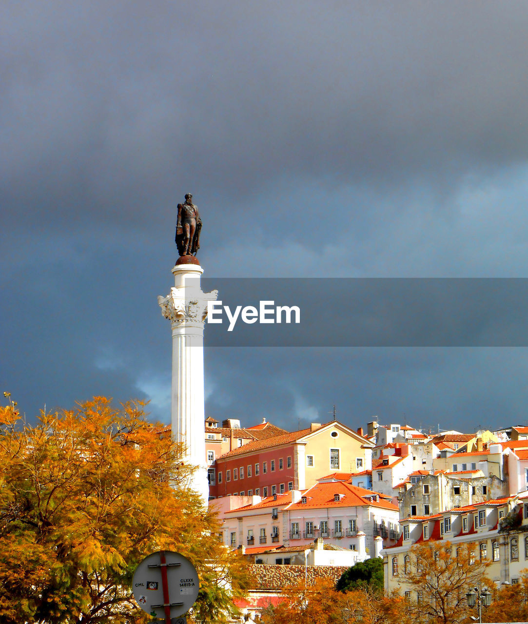 Marques de pombal statue in lisbon with rooftops and stormy clouds
