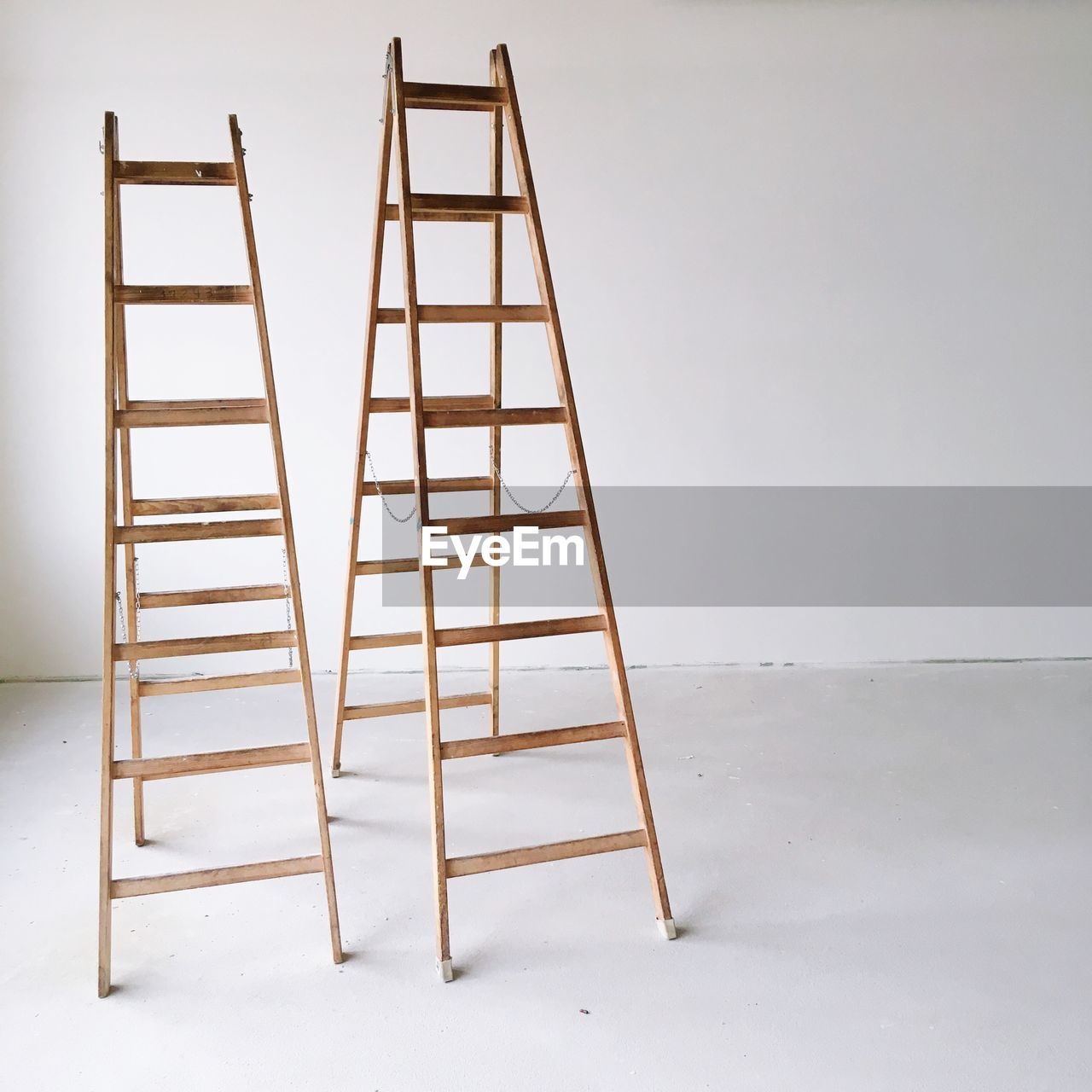 Close-up of ladders against wall