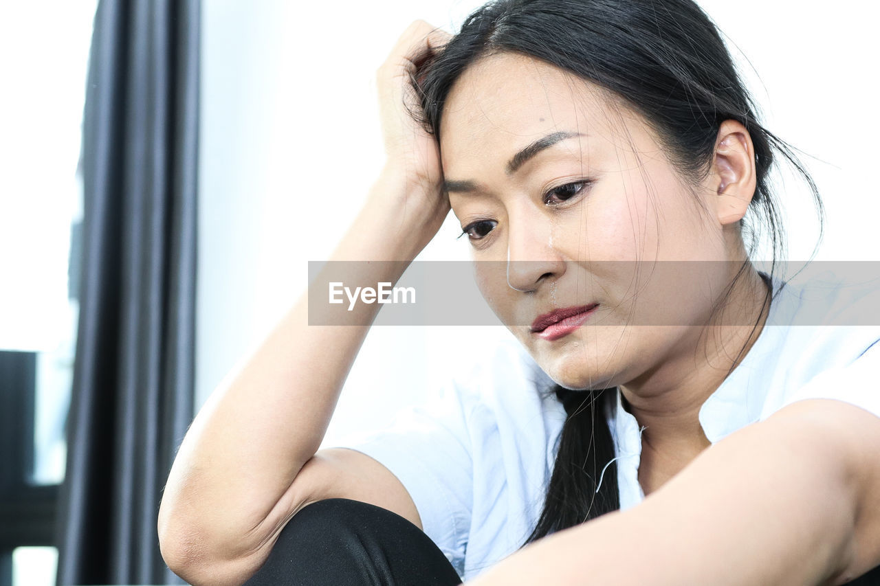 CLOSE-UP PORTRAIT OF A YOUNG WOMAN SITTING