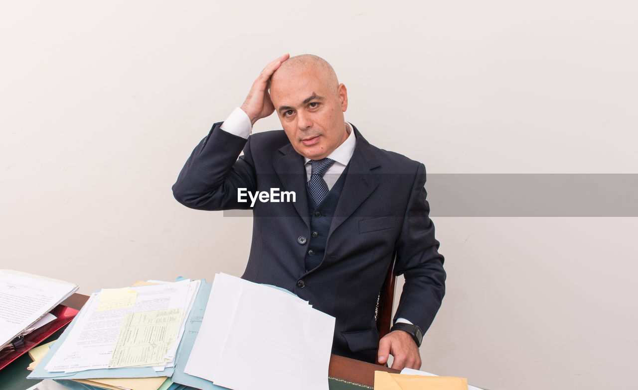 Portrait of businessman sitting at desk in office