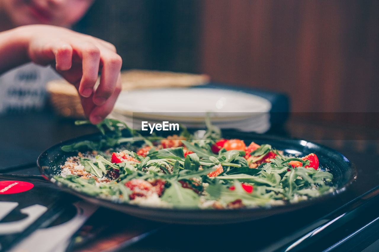 CLOSE-UP OF HAND HOLDING FOOD