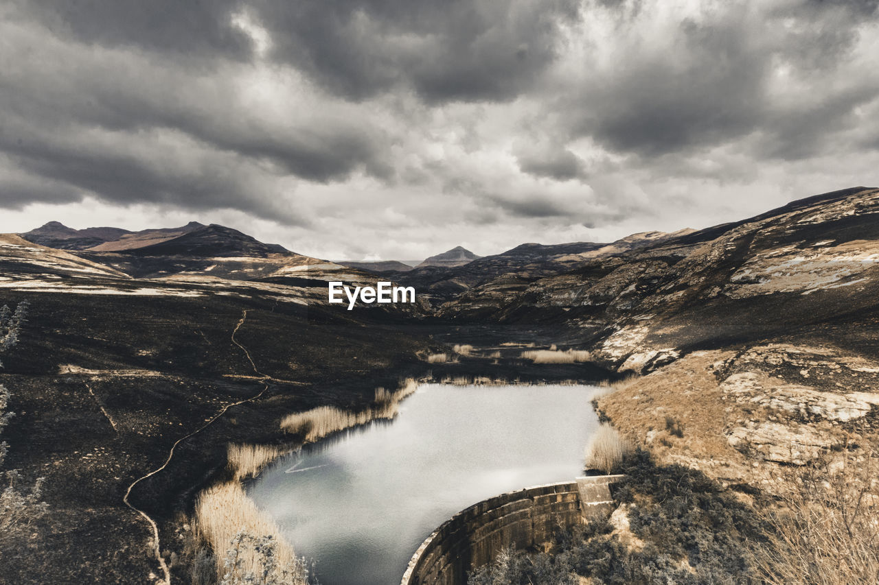 SCENIC VIEW OF LAKE BY MOUNTAIN AGAINST SKY