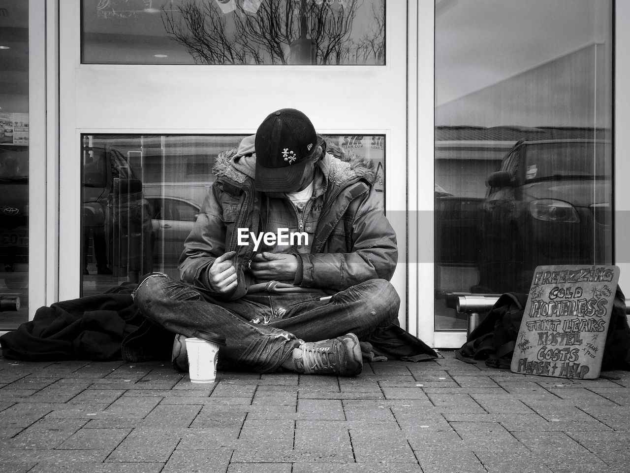 CLOSE-UP OF A MAN SITTING ON FLOOR IN ROOM