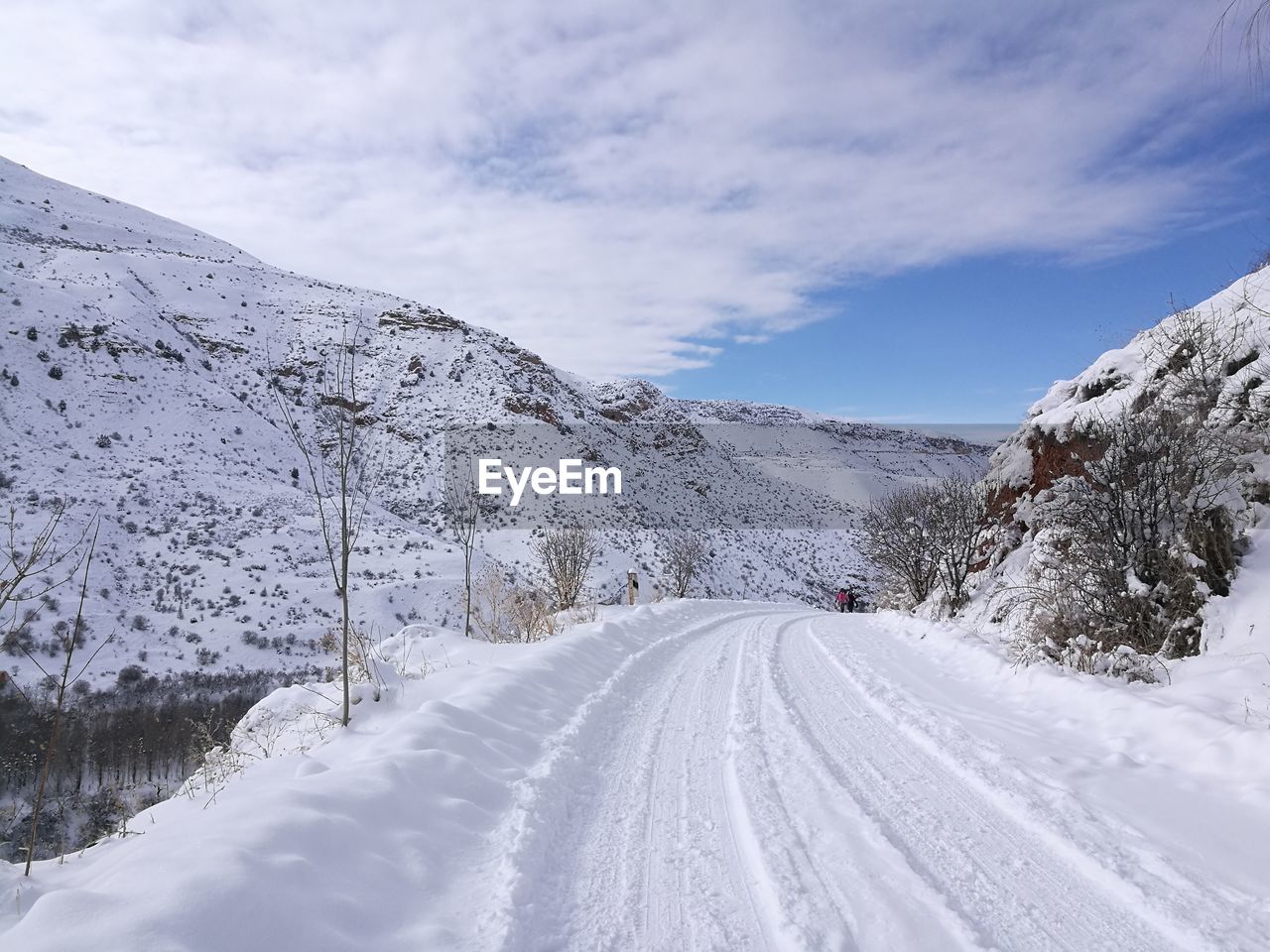 Road amidst snow covered mountains against sky